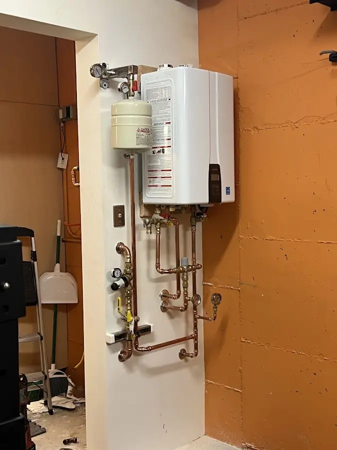 Plumbing technician inspecting water heater connections in Pacific Grove